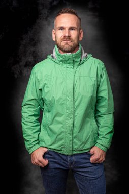 Koyu arkaplanda poz veren yakışıklı bir adam.