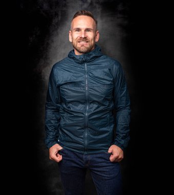 Koyu arkaplanda poz veren yakışıklı bir adam.