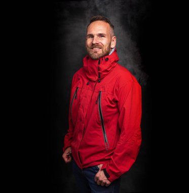 Koyu arkaplanda poz veren yakışıklı bir adam.