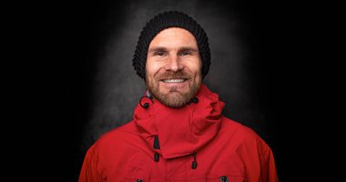 Esmer arka planda örgü şapkalı yakışıklı bir adam.