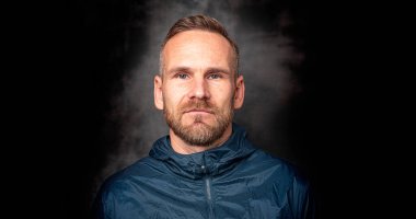 Koyu arkaplanda poz veren yakışıklı bir adam.