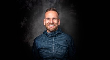 Koyu arkaplanda poz veren yakışıklı bir adam.