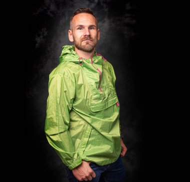 Koyu arkaplanda poz veren yakışıklı bir adam.