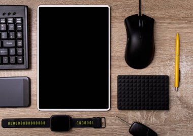 Tablet pc akıllı telefon klavye faresi ve çalışan ahşap bir masadaki sabit disk