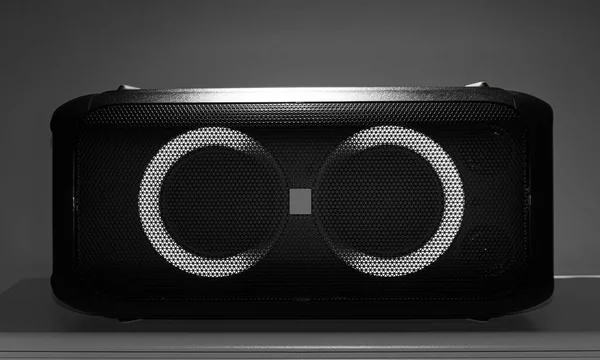 Portable big black speaker on a dark background.
