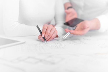 Ofisteki mühendisler proje çizimleri üzerinde görüşüyorlar..