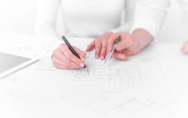 Ofisteki mühendisler proje çizimleri üzerinde görüşüyorlar..