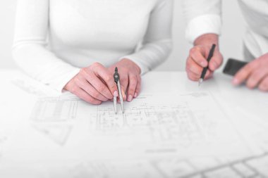 Ofisteki mühendisler proje çizimleri üzerinde görüşüyorlar..