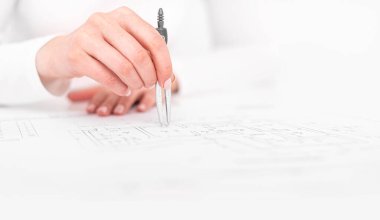 Bir mühendis çizimlerle çalışır. Bir kişi çizimler ya da planlar çizer