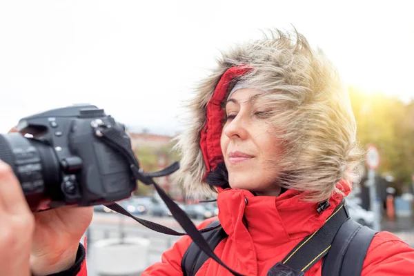 Mulher turista ou fotógrafa em uma jaqueta de inverno com uma câmera na rua — Fotografia de Stock