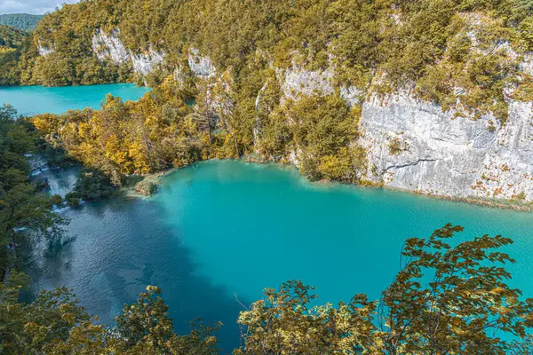 Um belo lago entre as montanhas cobertas com floresta de outono — Fotografia de Stock