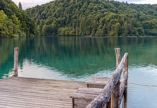 Sakin bir gölün üzerindeki tahta iskele.