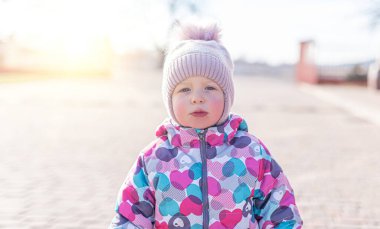 Sokakta giysi giymiş bir çocuk. Kız çocuk portresi