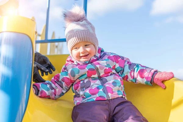 Kalın elbiseli çocuk kayıyor..