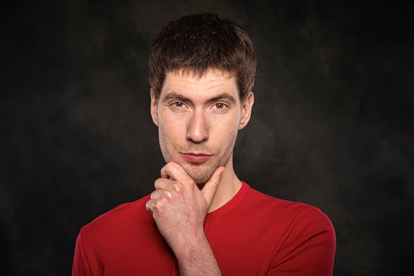 Portrait of a young man against a dark background — Stock Photo, Image