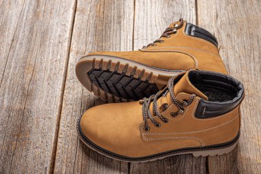 Ahşap arka planda sarı kış botları