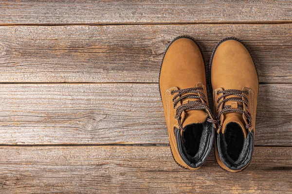 Yellow winter boots on a wooden background — Stock Photo, Image