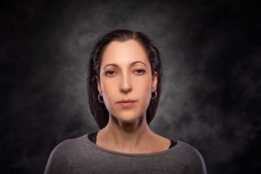 Koyu arkaplanda güzel esmer bir kadının portresi..