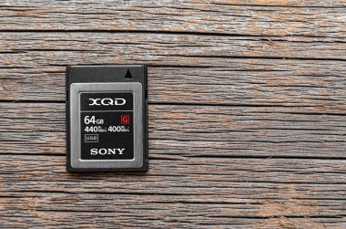 Ahşap bir arka planda Sony XQD hafıza kartı.