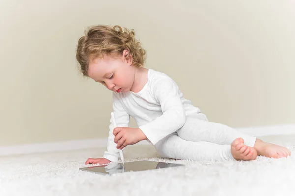 Niña dibuja o juega en la tableta. — Foto de Stock