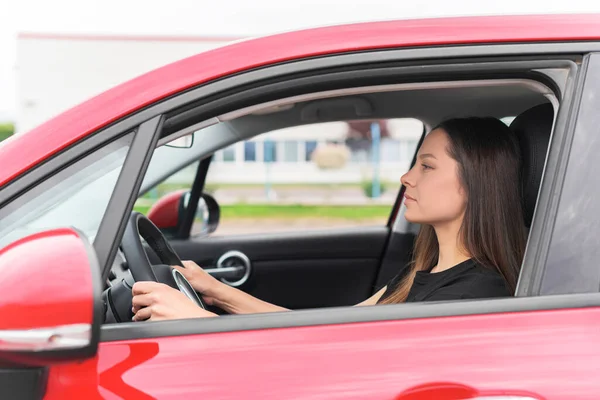 Hermosa mujer joven conduciendo un coche. — Foto de Stock