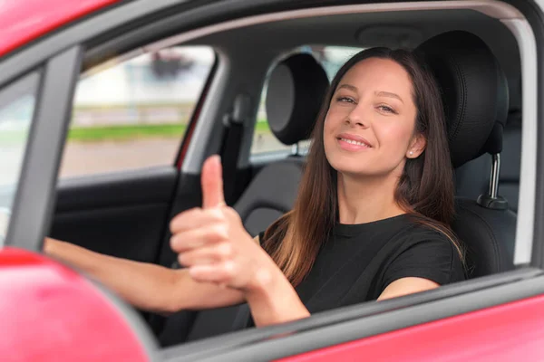 Mulher bonita no carro mostra polegares para cima. — Fotografia de Stock