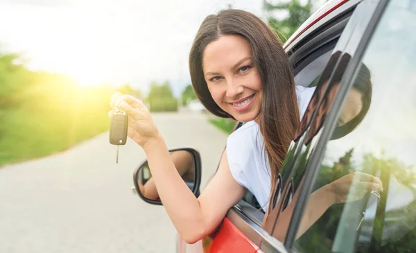 Aantrekkelijke jonge vrouw toont de sleutels van de auto. — Stockfoto
