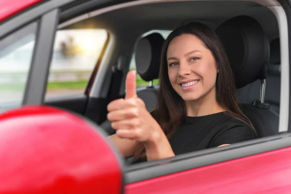 Mulher bonita no carro mostra polegares para cima. — Fotografia de Stock