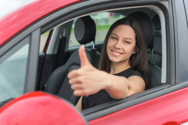 Mulher bonita no carro mostra polegares para cima. — Fotografia de Stock