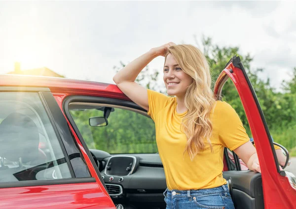 Vacker ung kvinna öppnar bildörren. — Stockfoto