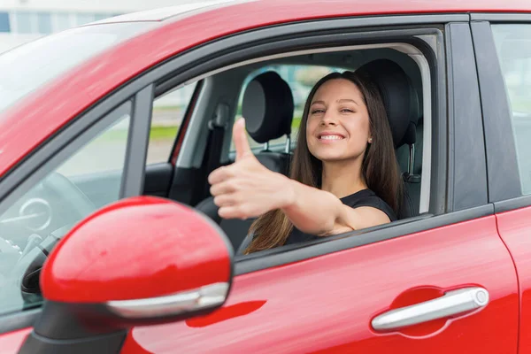 Hermosa mujer en el coche muestra pulgares hacia arriba. —  Fotos de Stock