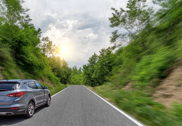 De auto rijdt op een bergweg op een zomerzonnige dag. — Stockfoto