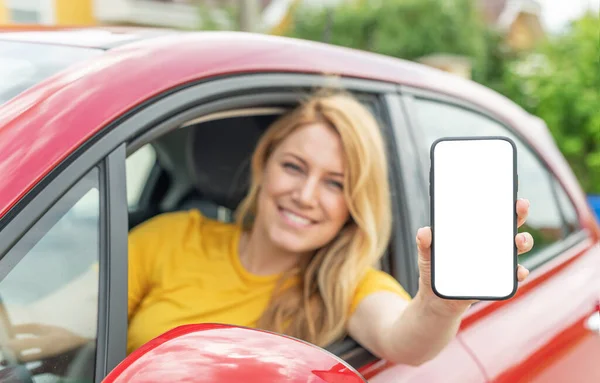 Jovem mulher dirigindo um carro mostra uma tela de smartphone. — Fotografia de Stock