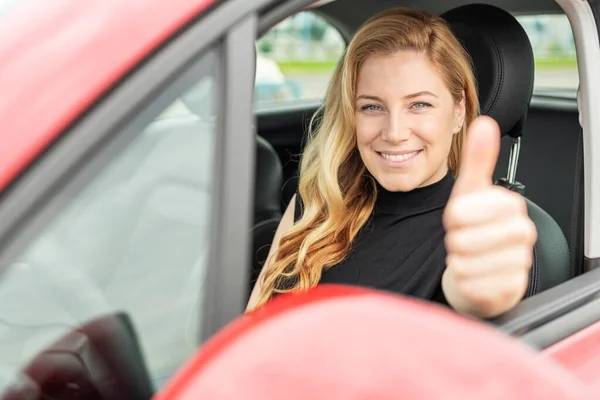 Mulher bonita no carro mostra polegares para cima. — Fotografia de Stock