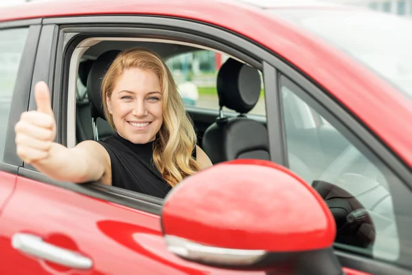 Mulher bonita no carro mostra polegares para cima. — Fotografia de Stock