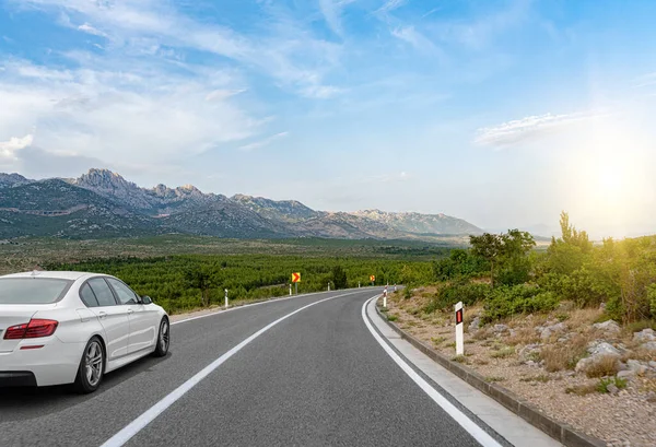 Auto jede po silnici. Bílé auto na příměstské dálnici. — Stock fotografie