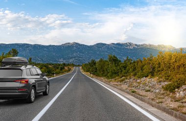 Araba yol boyunca gidiyor. Banliyö yolunda beyaz bir araba..