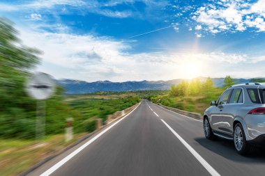 Araba yol boyunca gidiyor. Banliyö yolunda beyaz bir araba..