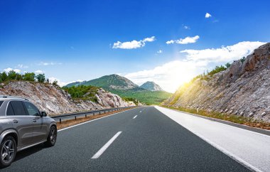 Araba yol boyunca gidiyor. Banliyö yolunda beyaz bir araba..