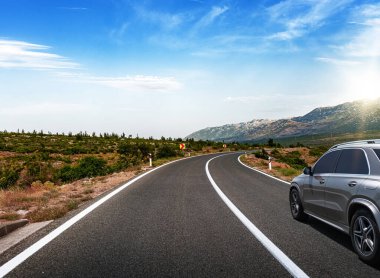 Araba yol boyunca gidiyor. Banliyö yolunda beyaz bir araba..
