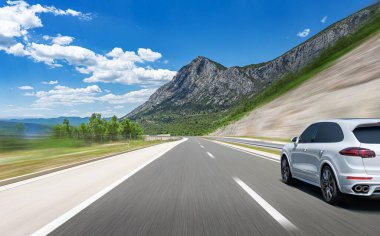 Araba yol boyunca gidiyor. Banliyö yolunda beyaz bir araba..