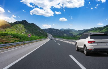 Araba yol boyunca gidiyor. Banliyö yolunda beyaz bir araba..