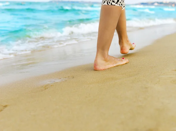 Femme marchant à travers le sable — Photo