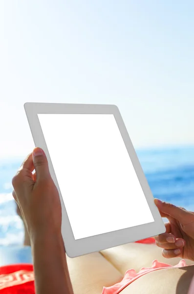 Vrouw met tablet pc op het strand — Stockfoto