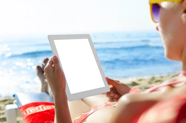 Vrouw met tablet pc op het strand — Stockfoto