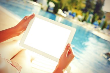 Yüzme havuzunda oturuyor tablet ile