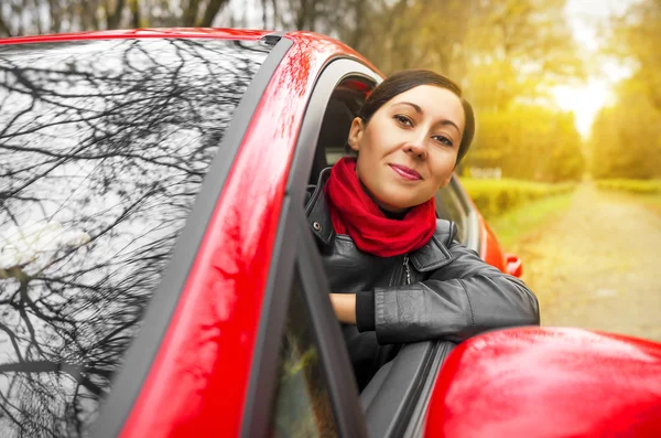 Mädchen fährt rotes Auto. — Stockfoto