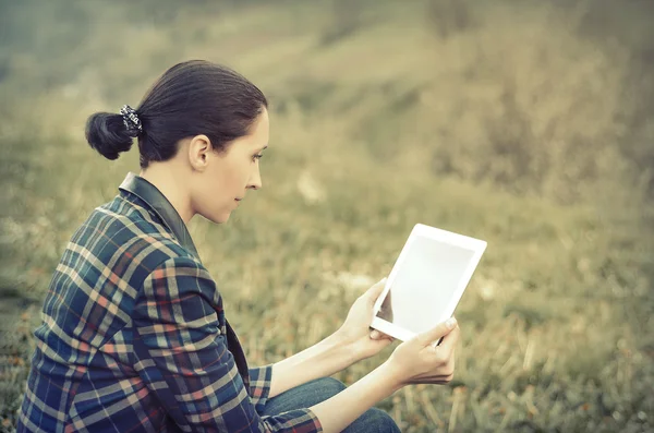 Jeune femme utilisant une tablette extérieure — Photo