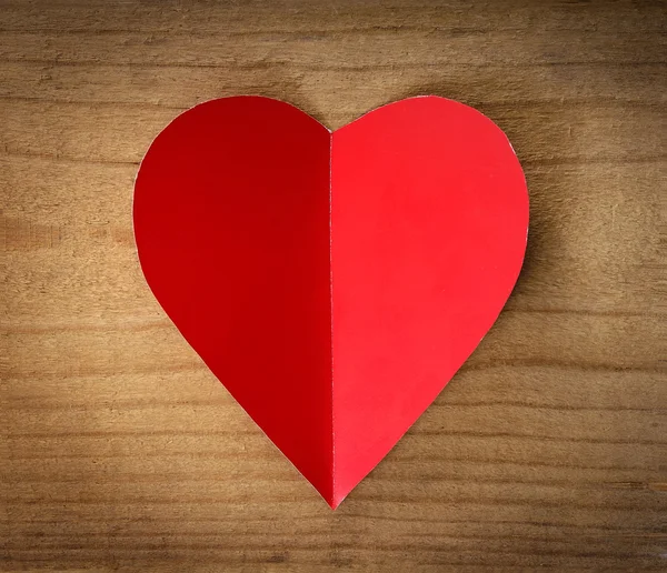 Corazón rojo sobre un fondo de madera. — Foto de Stock