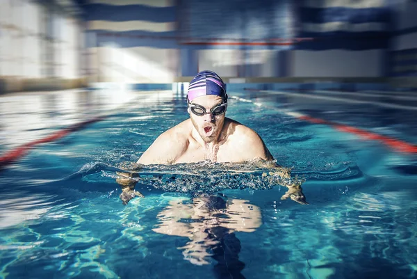 Swimmer in cap breathing performing the butterfly stroke — Stock Photo, Image